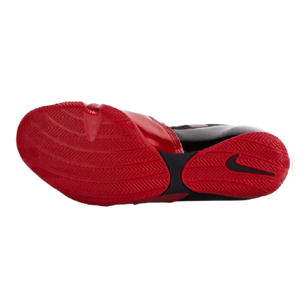 Low-profile red rubber outsole of Nike HyperKO 1 boxing shoe showing traction tread and black midfoot shank with Swoosh
